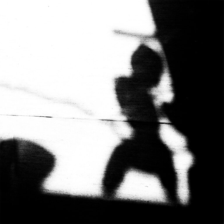 Blurred dark silhouette of a figure, high contrast black and white