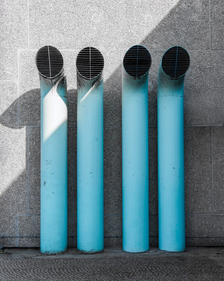 Urban hospital building, pipes against a rendered wall